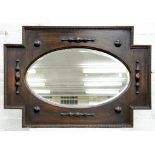 A CARVED OAK MIRROR WITH OVAL BEVELLED PLATE, EARLY 20TH C, 95CM W