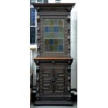 A NORTH EUROPEAN CARVED OAK BUFFET, THE UPPER PART GLAZED WITH STAINED AND LEADED GLASS, 225CM H; 98