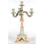 A SITZENDORF FLORAL ENCRUSTED CANDELABRUM, OF THREE LIGHTS SUPPORTED BY THE SEATED FIGURE OF