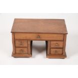 MINIATURE FURNITURE. A WALNUT KNEEHOLE DESK, 23.5CM L, EARLY 20TH C