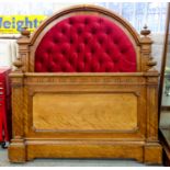 A VICTORIAN WALNUT BED, THE PADDED HEADBOARD UPHOLSTERED IN RED BUTTON BACK FABRIC, 144CM W