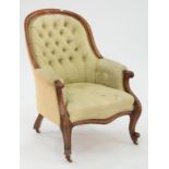 A VICTORIAN CARVED WALNUT ARMCHAIR, UPHOLSTERED IN BUTTON BACK FABRIC