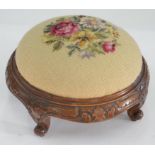 A VICTORIAN CARVED WALNUT FOOTSTOOL, WITH EMBROIDERED TOP, 33CM D