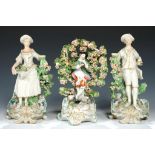 A PAIR OF DERBY CANDLESTICK FIGURES OF A SHEPHERD AND SHEPHERDESS AND A DERBY BOCAGE FIGURE OF A