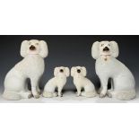 TWO PAIRS OF STAFFORDSHIRE EARTHENWARE MODELS OF POODLES, C1870 both with a 'clipped' coat of '