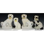 A PAIR OF STAFFORDSHIRE EARTHENWARE MODELS OF LITTLE LION DOGS WITH BASKETS, C1850 having free