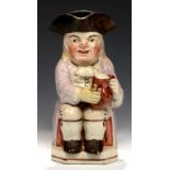 A STAFFORDSHIRE EARTHENWARE TOBY JUG, C1830 with warty face and mauve coat, 24cm h++Professional