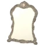 A GEORGE V CARTOUCHE SHAPED SILVER DRESSING MIRROR, WITH ROCOCO STYLE PIERCED AND EMBOSSED MOUNT,