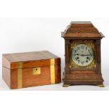 A GERMAN STAINED OAK MANTEL CLOCK, THE CASE WITH BASKET TOP, ON OGEE BRASS FEET, 26CM H, EARLY