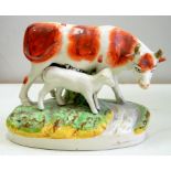 A STAFFORDSHIRE EARTHENWARE COW AND CALF GROUP, 16CM H, 19TH C