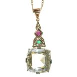 A CUSHION SHAPED FACETED QUARTZ PENDANT IN FOLIATE MOUNT WITH EMERALD AND RUBY ACCENTS ON SILVER