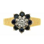 A SAPPHIRE AND DIAMOND CLUSTER RING WITH TEXTURED SHOULDERS IN GOLD MARKED 18CT, 5G, SIZE O++