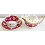 A ROCKINGHAM CLARET GROUND TEACUP, SAUCER AND CREAM JUG, PAINTED WITH TRAILING FLOWERS, JUG 9CM H,