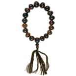 A STRING OF NINETEEN CHINESE AMBER PRAYER BEADS WITH BROWN SILK TASSEL, BEADS 22.5MM DIAMETER,