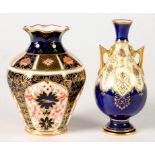 A COALPORT MINIATURE COBALT GROUND BOTTLE SHAPED VASE AND COVER, DECORATED WITH ROSES ON A