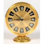 A JAEGER GILTMETAL RECITAL ALARM CLOCK, IN FILIGREE DECORATED ROUND CASE ON DOMED FOOT, 10CM H