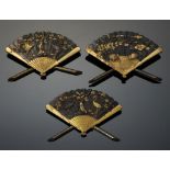 A SET OF THREE JAPANESE BRASS AND MIXED METALS FAN SHAPED MENU OR PLACE STANDS, MEIJI PERIOD 5.6cm