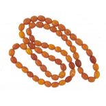 A NECKLACE OF SIXTY SIX AMBER BEADS 78g++Good condition
