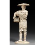 A TOKYO SCHOOL IVORY OKIMONO OF A FISHERMAN, MEIJI PERIOD carrying a basket and holding a crayfish