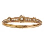 A FRENCH CULTURED PEARL AND GOLD ARTICULATED BANGLE, C1900 applied with three stylised