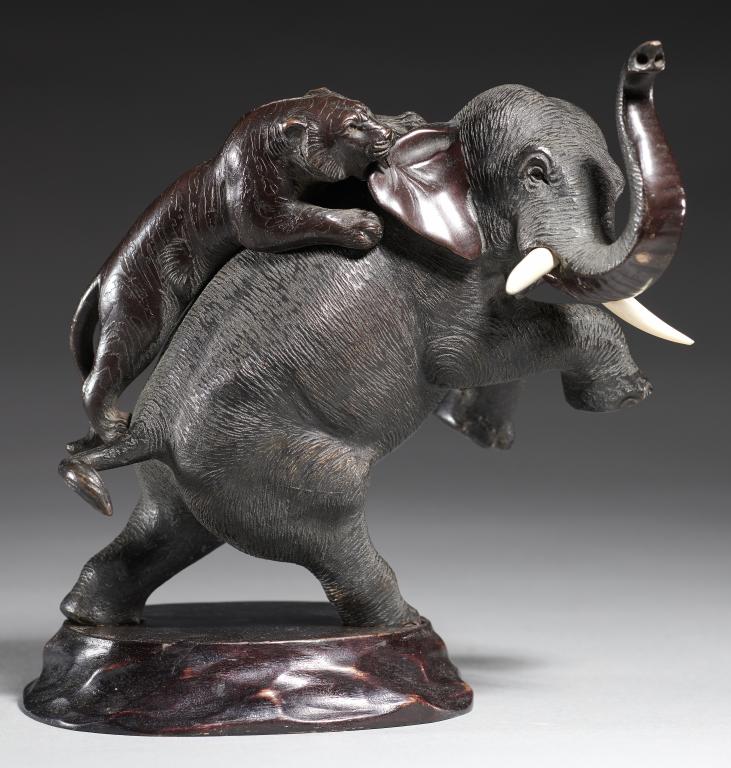 A JAPANESE BRONZE SCULPTURE OF AN ELEPHANT ATTACKED BY A TIGER, MEIJI PERIOD with ivory tusks,