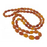 A NECKLACE OF SIXTY-THREE AMBER BEADS 39.6g++++