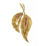 A RUBY BROOCH IN THE FORM OF TWO LEAVES in 18ct gold, 5.4cm, import marked London 1963, 9.4g++Good