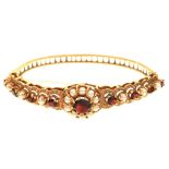 A GARNET AND PEARL BANGLE, IN GOLD, 17G++IN GOOD CONDITION, WITH LIGHT WEAR CONSISTENT WITH AGE