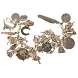 A SILVER CHARM BRACELET, THE THIRTY SILVER CHARMS INCLUDING A 1887 SIXPENCE, 92G++GENERAL WEAR