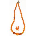 A BUTTERSCOTCH AMBER NECKLACE, APPROX 43 CM, LARGEST BEAD 19.7X15.7MM, AND SEVERAL LOOSE
