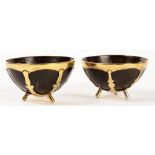 A PAIR OF ARTS AND CRAFTS BRASS MOUNTED COCONUT BOWLS, ON THREE FEET, 8.5CM DIAM, 20TH C