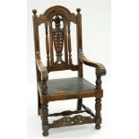 AN OAK ELBOW CHAIR WITH CARVED VASE SPLAT AND BREAK ARCHED CREST RAIL, 126CM H, EARLY 20TH C