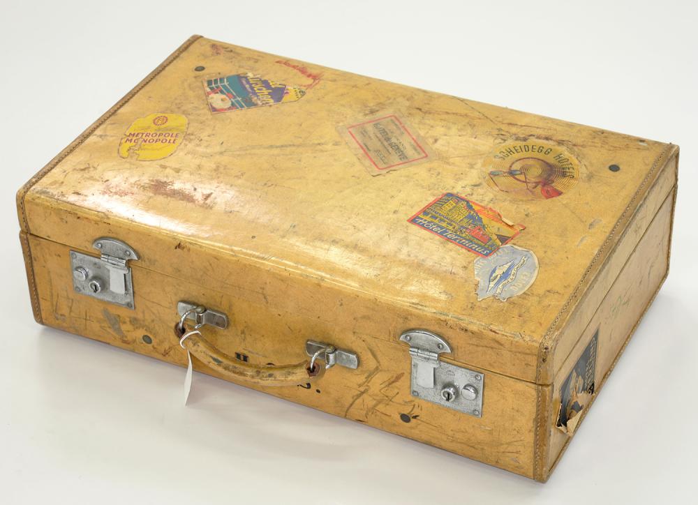 A VELLUM COVERED SUITCASE, LABELLED W. E. JACKSON AND SON NOTTINGHAM WITH NUMROUS TRAVEL LABELS,