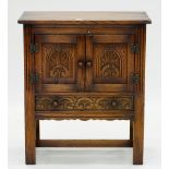 A CARVED OAK HUTCH WITH TWIN PANELLED DOORS ABOVE DRAWER, TURNED KNOBS AND STILES, 68CM L