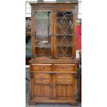 AN OAK BOOKCASE, THE UPPER PART WITH LEADED GLASS DOORS, 93CM L