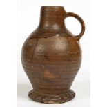 A SALTGLAZED STONEWARE BOTTLE, OVOID WITH RILLED BODY AND STRAP SHOULDER-HANDLE, ON THUMBED FOOT,