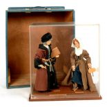 COSTUME DOLLS. AN EARLY 16TH C SCRIBE OR CLERK AND WOMAN IN PATTENS, ON WOOD BASE AND ACRYLIC