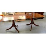 A GEORGE III STYLE MAHOGANY TWIN PILLAR DINING TABLE ON BRASS CASTORS, WITH ONE LEAF, 74CM H; 212