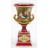 A VIENNA STYLE CLARET GROUND CAMPANA VASE ON PEDESTAL, DECORATED WITH MAIDENS AND PUTTI, 28CM H,