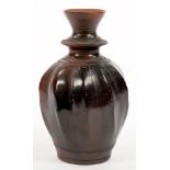 AN EGYPTIAN FLUTED AND BURNISHED TERRACOTTA VASE, 22CM H