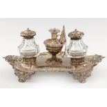 A VICTORIAN PIERCED SILVER INKSTAND the detachable taperstick flanked by silver mounted, faceted