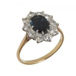 A SAPPHIRE AND DIAMOND CLUSTER RING the oval blue/green sapphire approx 1.4 ct, the brilliant cut