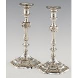 A PAIR OF GEORGE III GADROONED SILVER CANDLESTICKS crested, nozzles, 29cm h, marked underneath, on