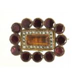 A GEORGIAN FLAT CUT GARNET AND SEED PEARL BROOCH with central foiled citrine, in gold, 2.2 cm