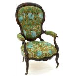 A LATE VICTORIAN CARVED WALNUT ELBOW CHAIR UPHOLSTERED IN FLORAL BUTTON BACK FABRIC