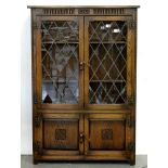 A JACOBEAN STYLE CARVED OAK BOOKCASE, THE UPPER PART WITH GLAZED DOORS, 152CM H; 102 X 30CM