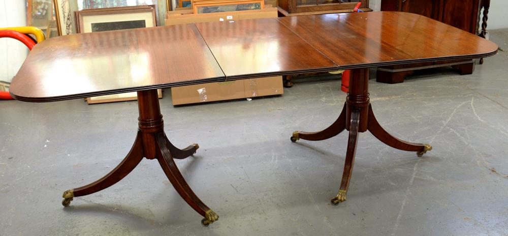 A GEORGE III STYLE MAHOGANY TWIN PILLAR DINING TABLE ON BRASS CASTORS, WITH ONE LEAF, 74CM H; 212