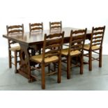 AN OAK DRAW LEAF TABLE AND SET OF SIX OAK RUSH SEATED LADDER BACK DINING CHAIRS