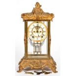 AN ORNATE FRENCH CAST GILTMETAL FOUR GLASS MANTEL CLOCK, WITH BROCOT ESCAPEMENT, ENAMEL DIAL AND