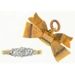 A THREE STONE DIAMOND RING IN GOLD MARKED 18CT, SIZE Q, AND A 9CT GOLD BOW BROOCH++LIGHT WEAR